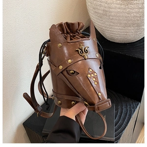 Macro detail of brown horse-head bucket bag with fleur-de-lis metal badge and rivets