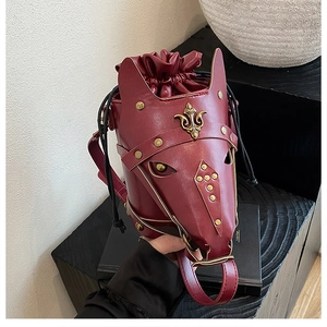 Macro view of horse head bucket bag showing wine red faux leather and gold studs