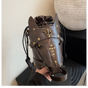 Detail of horse head bucket bag showing brown leather texture and gold rivet studs