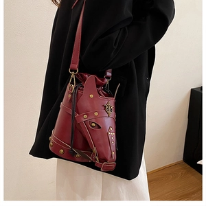 Detail of horse-head bucket bag showing dark red PU leather and vintage stud accents