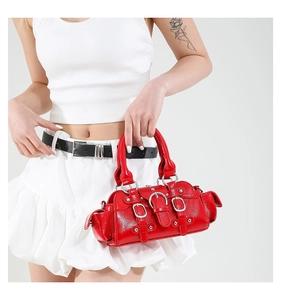 Vue détaillée du sac moto en cuir verni rouge avec boucles métalliques argentées