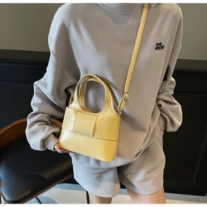 Détail d'un sac à main jaune crème avec nœud plissé en cuir mat et finitions argentées
