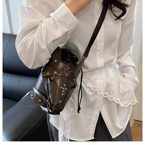 Detail of vintage brown bucket bag with unique horse mask design and bronze metal studs