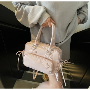 Détail du sac à main en PU rose brillant avec trois nœuds 3D décoratifs et doubles zips