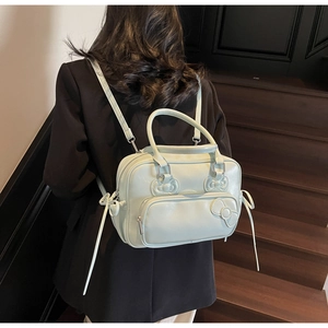 Detail view of mint green PU leather backpack with decorative bows and adjustable straps