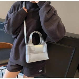 Détail d'un sac seau argenté métallisé avec nœud élégant et texture lisse