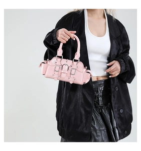 Détail du sac à main rose style motard avec boucles métalliques et sangles rivetées