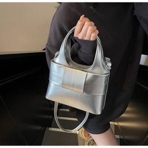 Détail du sac à main argenté à nœud avec finition métallisée et fine bandoulière