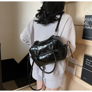 Détail du sac à dos en PU noir brillant avec poches fonctionnelles à fermeture éclair