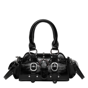 Détail d'un sac à main en cuir verni noir avec boucles argentées et quincaillerie punk