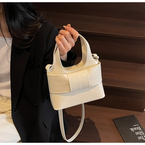 Détail du sac seau blanc avec grand nœud et bandoulière amovible et réglable