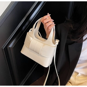 Détail du sac seau crème minimaliste avec grand nœud décoratif et bandoulière réglable