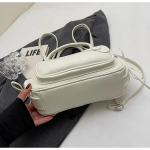 Vue latérale du sac à dos en PU crème avec poche latérale et boucles argentées