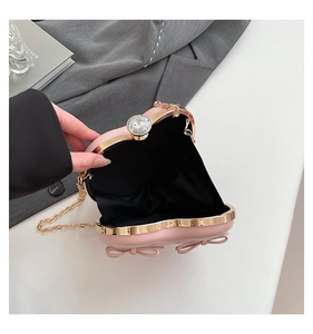 Macro view of heart-shaped evening bag showing pink satin interior and crystal clasp