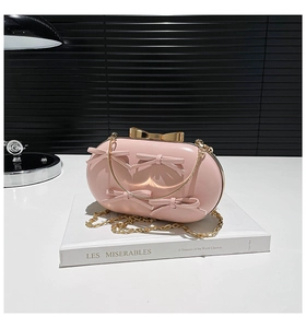 Close-up of pink oval evening bag with 3D bows and gold metal butterfly clasp