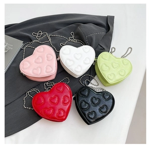 Overhead view of colorful heart-shaped mini chain bags with quilted leather detail