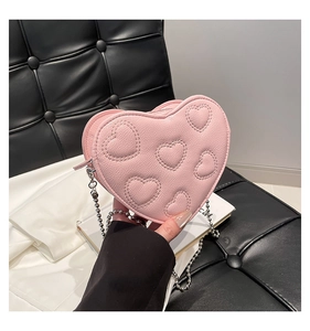 Detailed view of pink heart-shaped bag with embossed hearts and silver ball chain strap