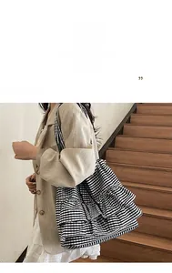 Detail of checkered canvas tote bag with layered ruffle folds and large storage space