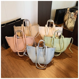 Litchi pattern tote bags in five pastel colors arranged on a minimalist wood floor