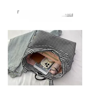 Flat lay of checkered tote bag interior with pink lining and organized daily essentials