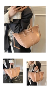 Detail of pink leather tote bag with lychee texture and drawstring side accents