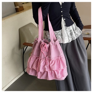 Detail of pink gingham fabric tote bag with ruffled layers and drawstring closure