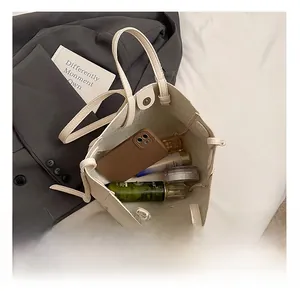 Interior view showing large capacity of the beige faux leather tote bag with daily essentials