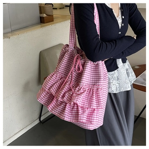 Detail view of pink and white checkered tote bag with ruffles and drawstring closure