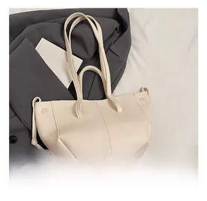 Chic beige lychee grain tote bag placed on a grey suit jacket for professional commuting