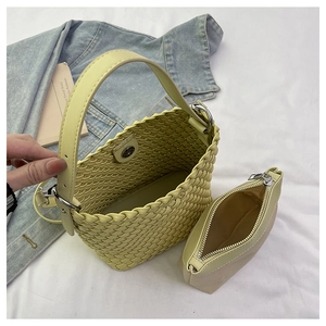 Detail view of woven bucket bag with matching inner pouch and adjustable leather strap