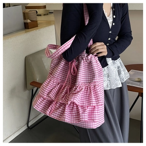 Detail of pink gingham tote bag with ruffle layers and functional drawstring closure