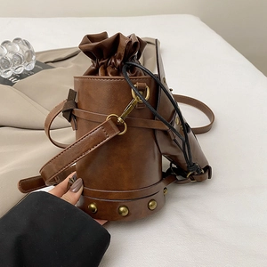 Retro brown leather bucket bag with horse head mask accent and rivet details