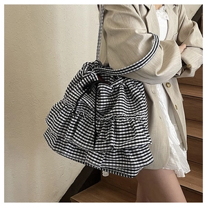 Detail of gingham canvas tote bag with ruffled layers and black drawstring closure
