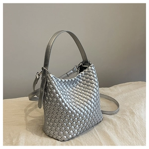 Detail shot of silver woven bucket bag with metallic texture and sleek shoulder strap