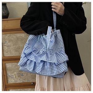 Detail of blue gingham tote bag showing triple-layered ruffles and drawstring closure
