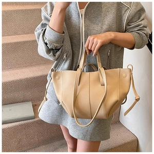 Detail der beigen Shopper-Tasche aus Leder mit Lychee-Muster und seitlichem Kordelzug
