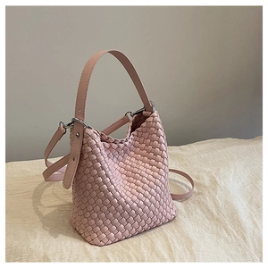 Close-up of pink woven bucket bag texture with adjustable strap and silver rings