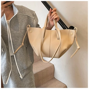 Detailansicht der beigen Lychee-Ledertasche mit seitlichem Kordelzug und Schulterriemen