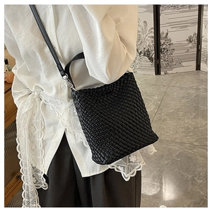 Detail of black woven bucket bag showing intricate texture and silver metal hardware