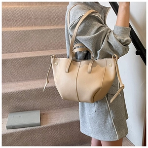 Detail der beigen Shopper-Tasche aus Leder mit Kordelzug-Dekor auf Teppichstufen