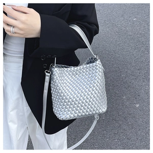 Detailed view of metallic silver woven texture on a versatile bucket handbag strap