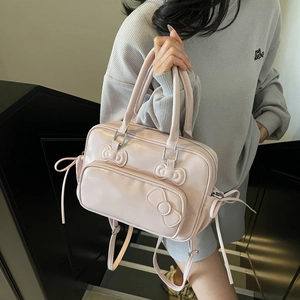 Sac à dos en cuir PU rose avec nœuds décoratifs présenté dans un cadre extérieur élégant