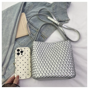 Detail view of silver woven tote bag with adjustable strap and interior pouch insert