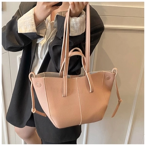 Hellrosa Tote-Bag aus genarbtem Leder getragen zum schwarzen Blazer für das Büro