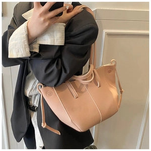 Detail of pink lychee textured leather tote bag with side drawstring and stitching