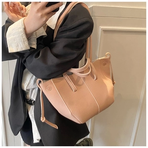 Nahaufnahme der rosa Ledertasche mit Kieselmaserung, Seitenprofil und Kordelzug-Detail