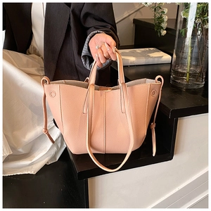 Detail of peach pink lychee grain leather tote bag with unique fold bucket design
