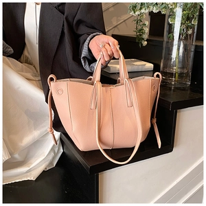 Detailansicht der pink-orangen Tragetasche mit Litschistruktur und langem Schultergurt