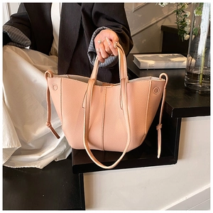 Detaillierte Makroansicht der rosa Ledertasche mit Narbung und stilvoller Knotenschleife