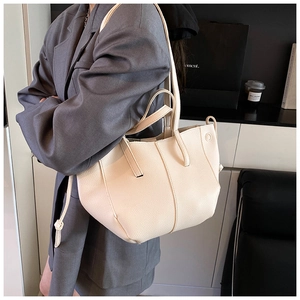 Detail view of beige tote bag with litchi texture and drawstring knots on the side